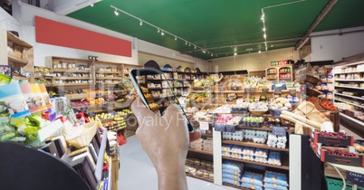 Hand using mobile phone in grocery store