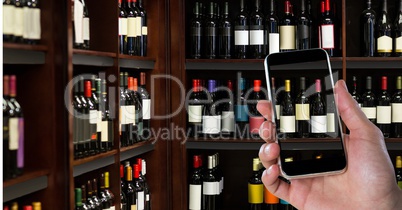 Hand photographing alcohol bottles