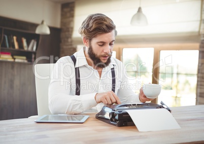 Hipster man  on typewriter in bright warm room