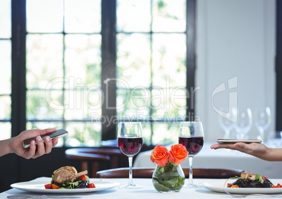 Couple holding phones over romantic dinner