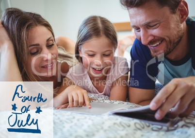 Family reading a book lying on bed for 4th of July