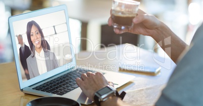 Cropped image of man having coffee while having video conference on laptop