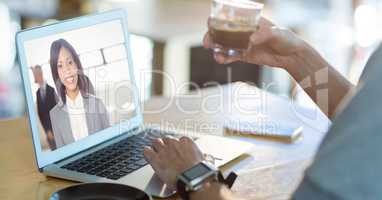 Cropped image of man having coffee while having video conference on laptop