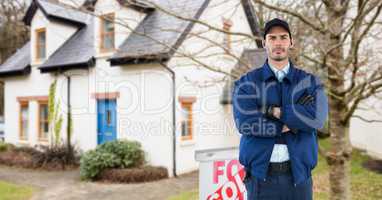 Security guard with arms crossed standing on road against house