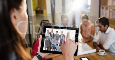 Female executive video conferencing with colleagues in office