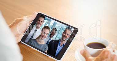 Cropped image of business person video conferencing with colleagues on tablet PC