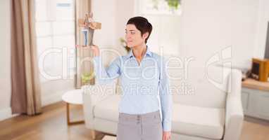 Businesswoman holding gift while standing in room against sofa