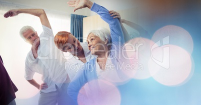 Female instructor assisting senior woman in exercising