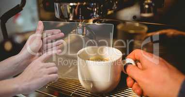 Hands taking picture of coffee with transparent device in coffee shop