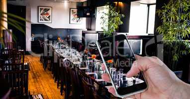 Hand photographing through smart phone in restaurant