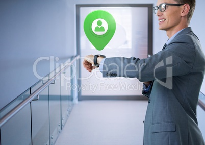 Businessman holding smart watch with app location marker in corridor