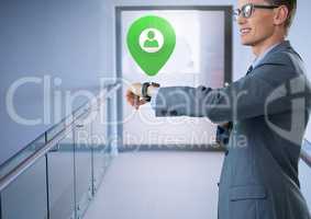 Businessman holding smart watch with app location marker in corridor