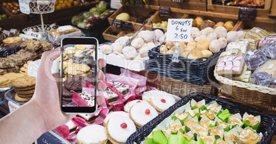 Hand photographing cookies at grocery store