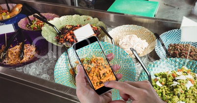 Hand photographing food served on plate through smart phone