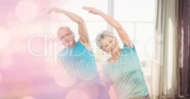 Senior man and woman exercising with bokeh in foreground
