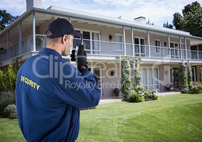 Security guard using radio outside house