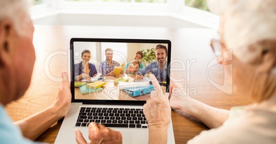 Senior man and woman using laptop for video conference