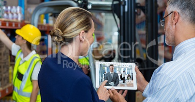 Business people video conferencing in warehouse