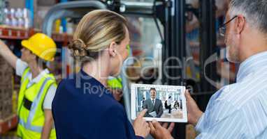 Business people video conferencing in warehouse