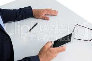 Businessman sitting at table and using mobile phone