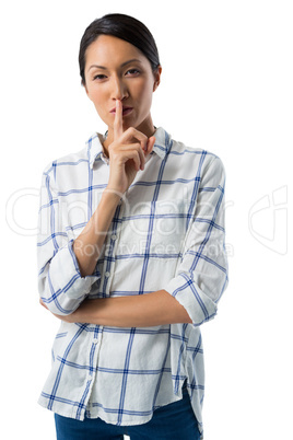 Portrait of woman standing with finger on lips