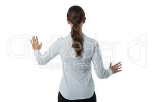 Female executive pretending to touch an invisible screen against white background