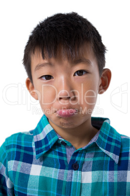 Cute boy making faces against white background