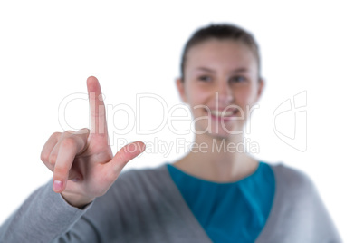 Smiling teenage girl pressing an invisible virtual screen