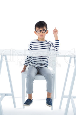 Boy sitting on chair against white background