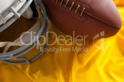 Close up of American football and helmet on jersey