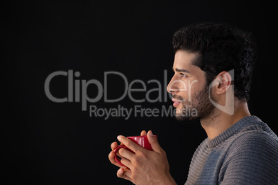 Thoughtful man holding a mug of coffee