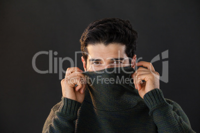 Portrait of man hiding face from scarf
