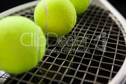 Close up of fluorescent yellow balls on tennis racket