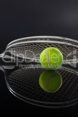 Symmetrical view of tennis racket on ball with reflection