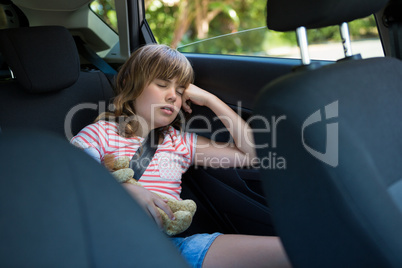 Teenage girl sleeping in the back seat of car