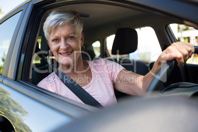 Happy senior woman driving a car