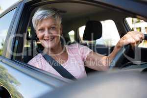 Happy senior woman driving a car