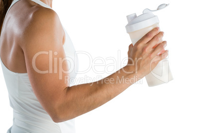 Mid section of female athlete holding bottle