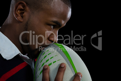 Close up of male player kissing rugby ball