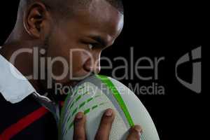 Close up of male player kissing rugby ball