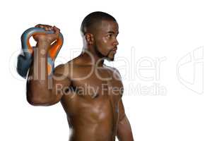 Shirtless male athlete lifting kettlebell