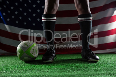 Low section of rugby player standing against American flag