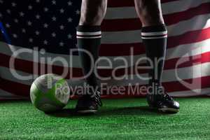 Low section of rugby player standing against American flag