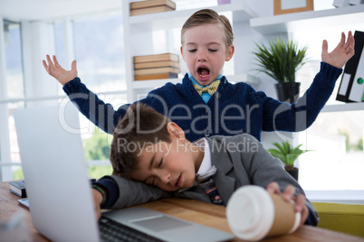 Boy as business executive sleeping while holding coffee cup