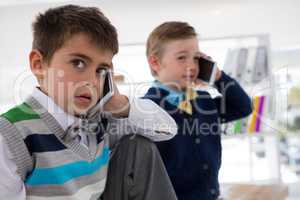 Kids as business executives talking on mobile phone