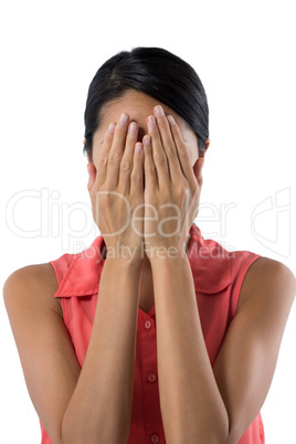Woman covering her eyes with hand against white background