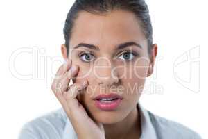 Surprised female executive standing against white background