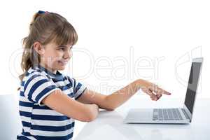 Cute girl using laptop at table