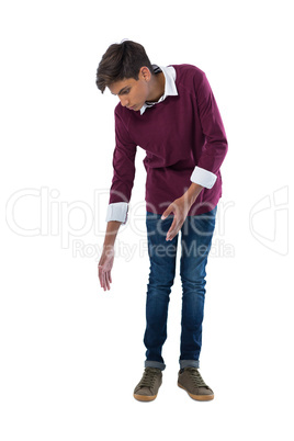 Teenage boy looking down against white background