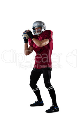 Focused American football player wearing helmet thorwing ball